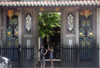 <b>Popular site:</b> Tourists admiring the paintings on the front door of Han Jiang Ancestral Temple ( Teow Chew Association ) in Chulia Street.” width=”400″ height=”274″ /> <span class=