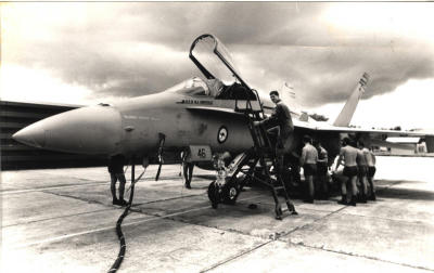 In 1989: RAAF Wing Commander Ross Fox climbing up a Hornet fighter aircraft as RAAF maintenance staff conduct pre-flight checks