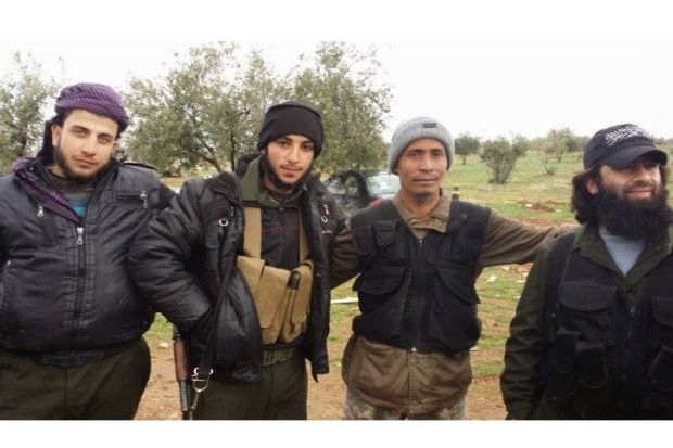 Brothers in arms: Lotfi (second right) posing with unidentified mujahideen fighters.