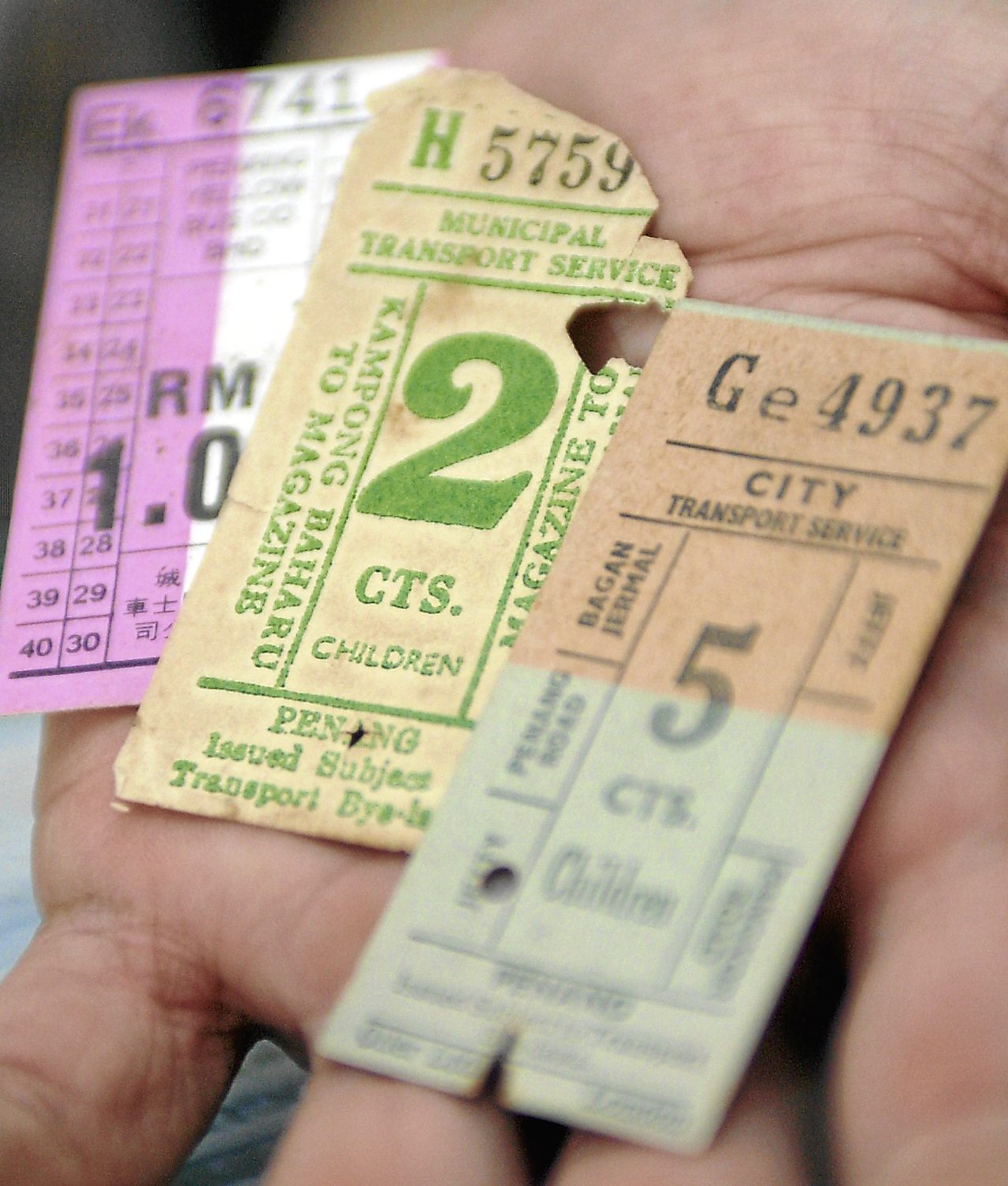 Avid numismatist and collector Danny Tan Swee Boon showing some of the old Penang tramway and Penang City Council bus tickets that he has in his collection.