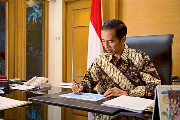 Ready to serve: Jokowi going through documents at his office in Jakarta. - AFP