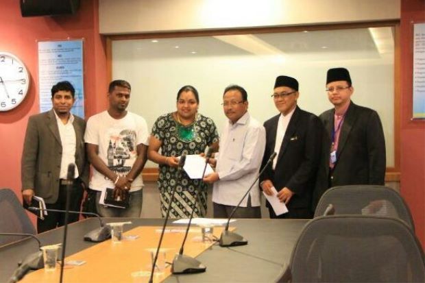 Zarena and Mohamad Adzib showing the press statement to reporters after their meeting while her family members and Jais officers look on.