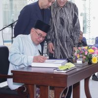 Prime Minister Datuk Seri Anwar Ibrahim (sitting) left his signature on the “Orientalist Painting : Mirror or Mirage?” book as Yayasan Al-Bukhary chairman Tan Sri Syed Mokhtar Al-Bukhary (right) and Syed Mohamaed Albukhary looks on at Islamic Arts Museum in Kuala Lumpur yesterday. — IZZRAFIQ ALIAS/The Star