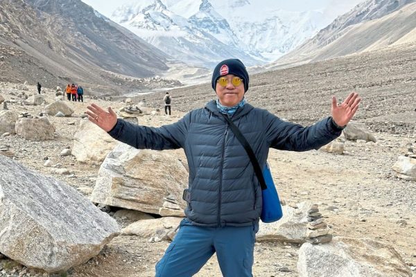 A view of the stunning Mount Everest behind the writer who took a bus trip to the base of the Mount Everest base camp in Tibet, the China side.