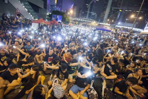 Pro-democracy protesters flash lights during a rally to protest the violence seen in Mong Kok, in Hong Kong, China, 4 October 2014. - EPA/ALEX HOFFORD